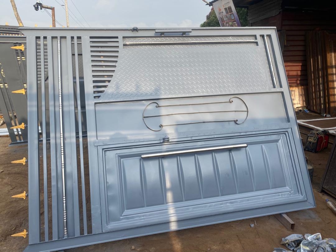 Light grey steel gate panel with geometric trim details.